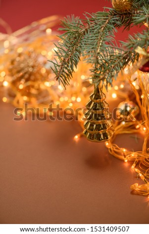 Christmas Golden toy on a spruce branch on the background of a Christmas garland . template for postcards . space for text