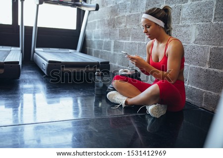 Young woman taking a break from her workout at the gym