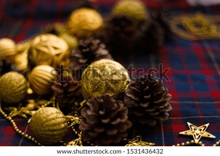 Christmas decorations cones and golden balls on the blue-red plaid background. New Year Flat lays concept. 