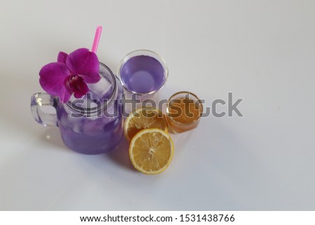 Healthy herbal beverage butterfly pea flower with honey bee and lemon and juice on white background - image  