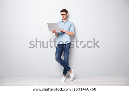 Full length body size photo of focused serious intelligent coworking manager standing confidently with legs crossed searching for news via internet connection isolated grey color background