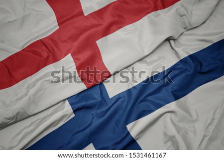 waving colorful flag of finland and national flag of england. macro