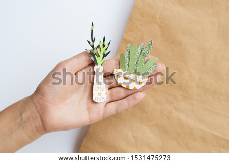 Cute variety of paper plants held in hand