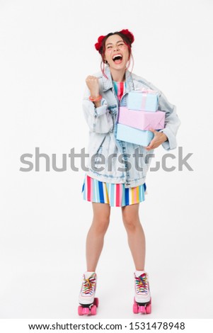 Image of delighted young woman in retro roller skates holding gift boxes and laughing isolated over white background