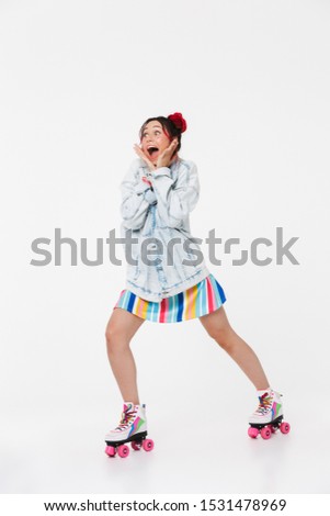 Image of astonished young woman in retro roller skates looking aside at copyspace isolated over white background