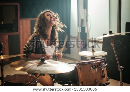 Woman playing drums during music band rehearsal Royalty-Free Stock Photo #1531503086
