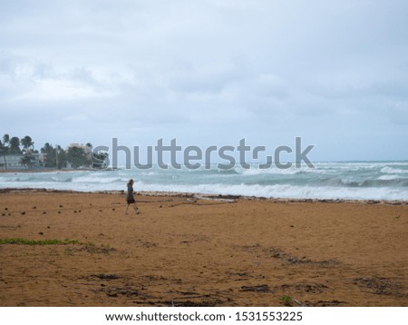 Girl walking by the sea before the storm, Luquillo, Puerto Rico