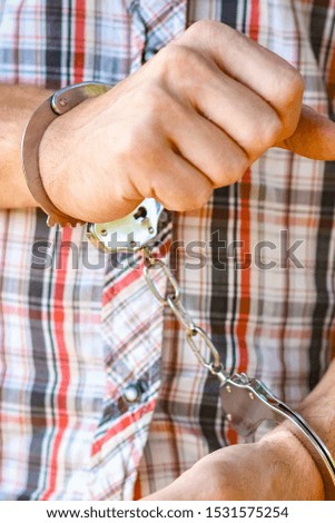 man handcuffed outdoors in the park