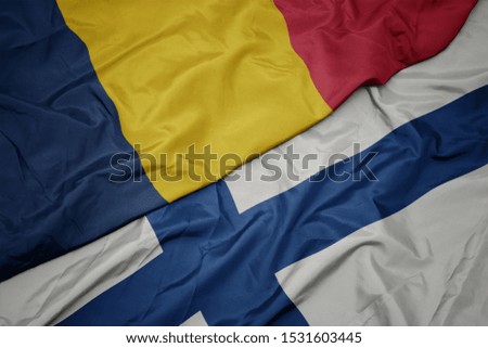 waving colorful flag of finland and national flag of chad. macro