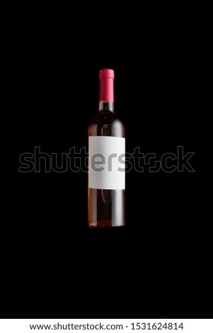 top view of bottle with rose wine and blank white label isolated on black