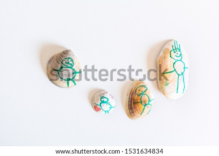 A Family hadmade painted over colorful sea shells, over a white background. Hobby as artistic development. Family concept