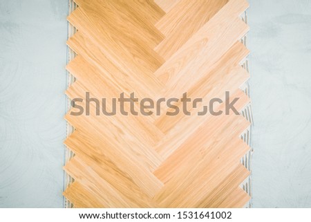 wooden floor background - herringbone parquet background with glue and stone underground