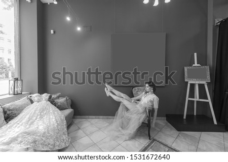 Young caucasian bride in peignoir relaxing in studio. Brides morning