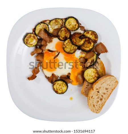 Image of plate with scrambled  eggs with lard and zucchini. Isolated over white background