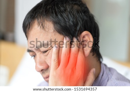 TMD and TMJ healthcare concept: Temporomandibular Joint and Muscle Disorder. Asia man hand on cheek face as suffering from facial pain, mumps or toothache Royalty-Free Stock Photo #1531694357