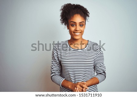African american woman wearing navy striped t-shirt standing over isolated white background with hands together and crossed fingers smiling relaxed and cheerful. Success and optimistic