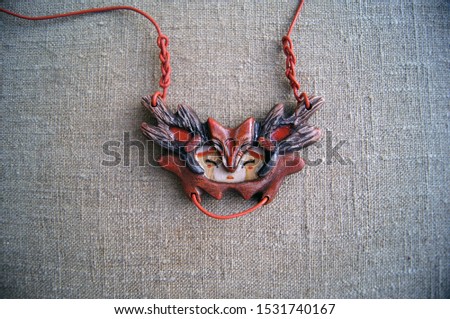  The Fox Creature. Unusual handmade jewelry. Traditional wooden decorations close-up detail photo. Decorations in folk style in the form of fantastic animals.             