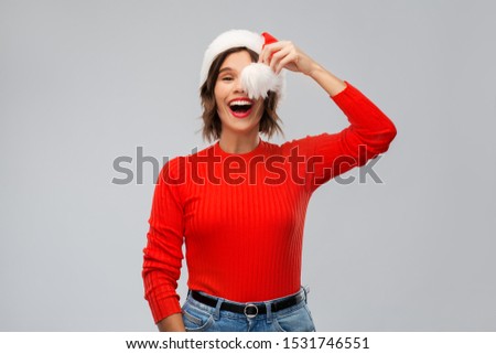 christmas, holidays and people concept - happy smiling young woman in santa helper hat over grey background