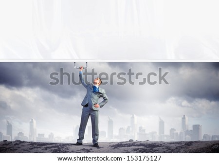 Image of young businessman pulling blank banner from above