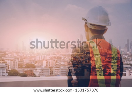Engineer close-up photos and looking at the city, double exposure, big city view, wide sunset effect, your business message area