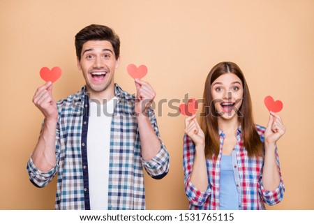 Photo of casual cheerful red redhair stylish cute charming beautiful couple rejoicing about having received new small red post cards isolated over beige color pastel background