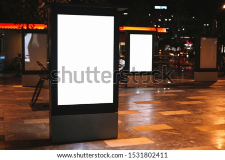 Street advertising mock up template with copy space. Outdoor commercial banner with white empty display on the night street
