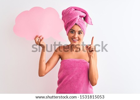 Beautiful woman wearing shower towel holding speech bubble over isolated white background very happy pointing with hand and finger to the side