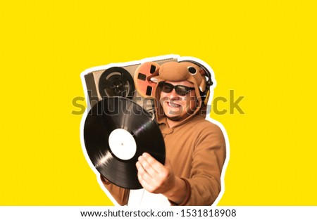 Man in cosplay costume of a cow with reel tape recorder isolated on yellow background. Guy in the animal pyjamas sleepwear. Funny photo with party ideas. Disco retro music.