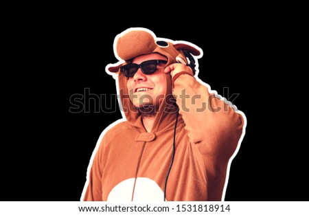 Man in cosplay costume of a cow isolated on black background. Guy in the animal pyjamas sleepwear. Funny photo with party ideas. Disco retro music.