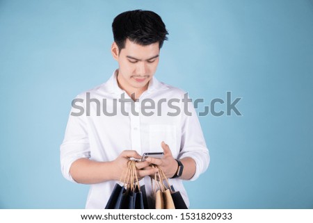 Portrait of confident modern young businessman on blue background asian