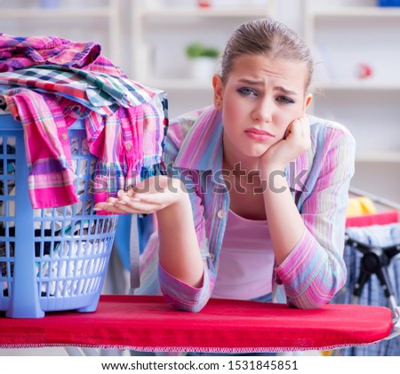 Tired depressed housewife doing laundry