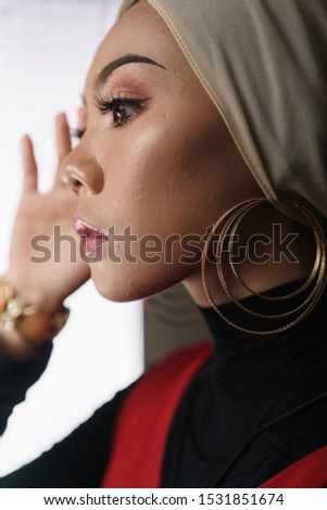 Beautiful female model wearing black inner and red dress with hijab, a modern lifestyle outfit  for Muslim woman isolated over grey background. Stylish hijab fashion lifestyle portraiture concept.