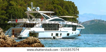 White luxury yacht anchored near the shore