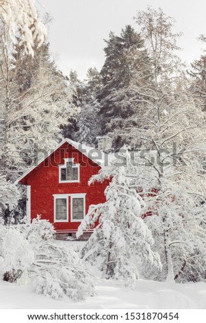 Beautiful red wooden house in snow fairy forest Sweden. House painted in traditional Swedish color. Winter scenery with red cottage surrounded by trees covered with snow and frost. Space for your text Royalty-Free Stock Photo #1531870454