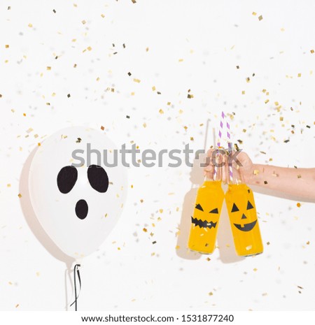 Halloween creative card. Party confetti flying down on balloon and drinks in bottles, white background