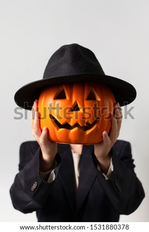 Halloween man with pumpkin head in Jack o Lantern costume over gray background, vertical panorama