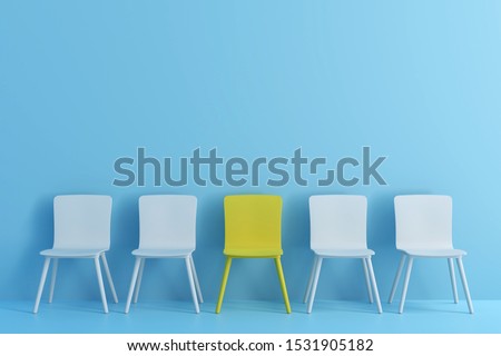 outstanding yellow chair among light blue chair. Chairs with one odd one out in light blue color room. Royalty-Free Stock Photo #1531905182