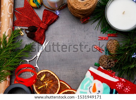beautiful preparation background for the Christmas holidays with a ribbon, Christmas tree, multi-colored trailers, glue and a candle