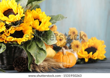 Autumn background with beautiful sunflowers and pumpkins.