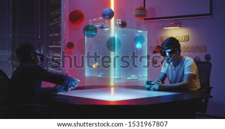 Medium long shot of teenagers playing holographic video game Royalty-Free Stock Photo #1531967807
