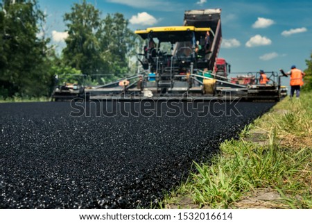 Layer of new hot asphalt laid by paver. Road construction.