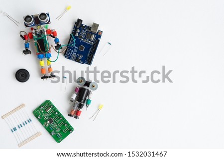 STEM school concept. A metal robot and an electronic board that can be programmed. Robotics and electronics. DIY robotics. STEM education for kids. Flat lay. Free space for text. White background. Royalty-Free Stock Photo #1532031467
