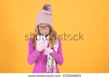 sheltered adult woman looking at mobile phone isolated on color background