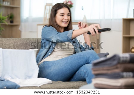young woman watching tv on sofa at home