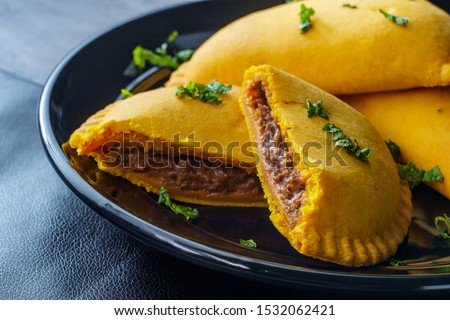 Spicy Jamaican beef turnovers with mint garnish Royalty-Free Stock Photo #1532062421