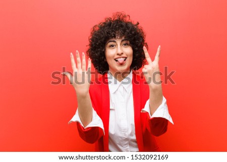 young pretty afro woman smiling and looking friendly, showing number seven or seventh with hand forward, counting down