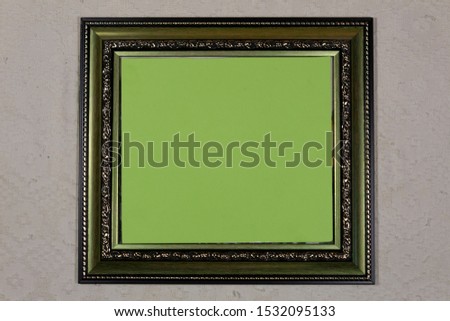Close-up. On a white background is a green picture frame, the middle of which is covered with green paper.