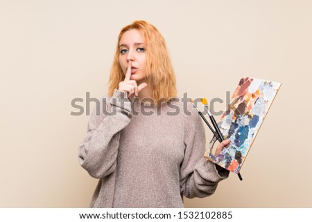 Young artist woman over isolated background doing silence gesture