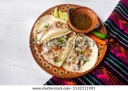 Traditional mexican pork tacos also called "carnitas" on white background