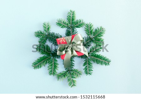 Christmas holiday composition. Gift box, fir tree branches, Xmas decorations on pastel blue background. Christmas, New Year, winter concept. Flat lay, top view, copy space